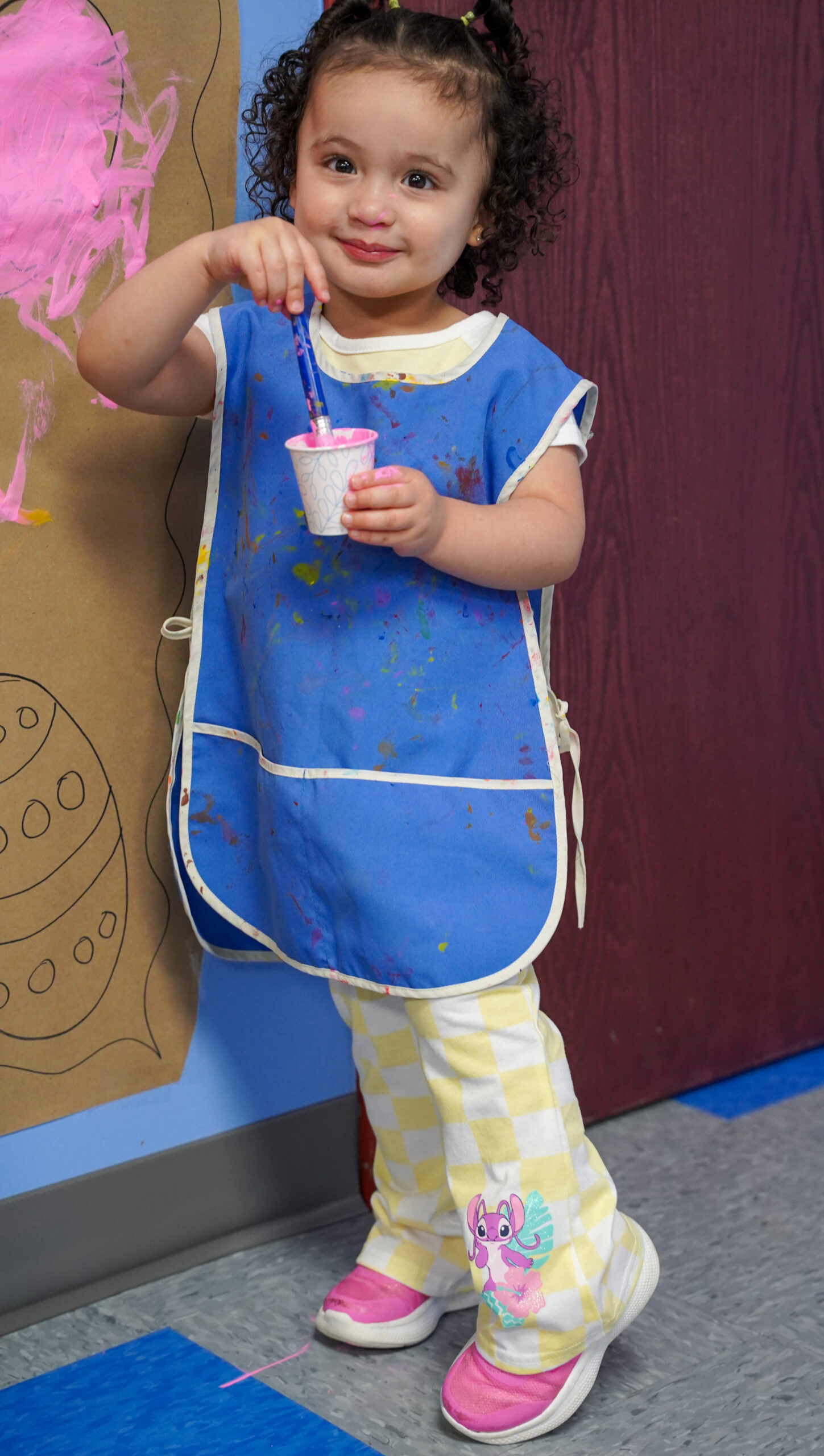 Child enjoying a creative painting activity at Los Solesitos Child Care Center